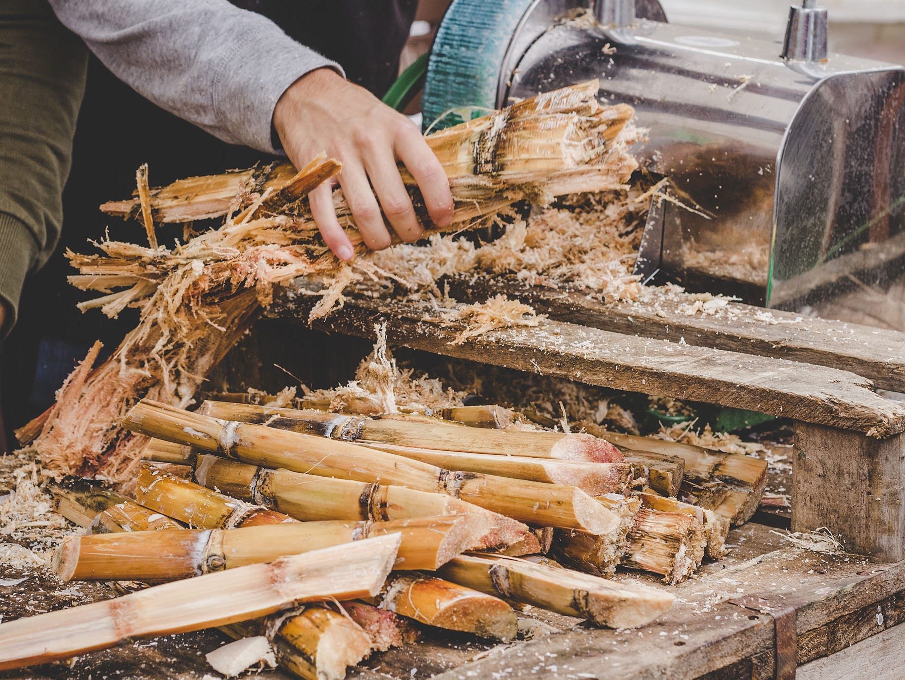 Man queezing sugar cane juice at street food market RO & UF für Kesselspeisewasser