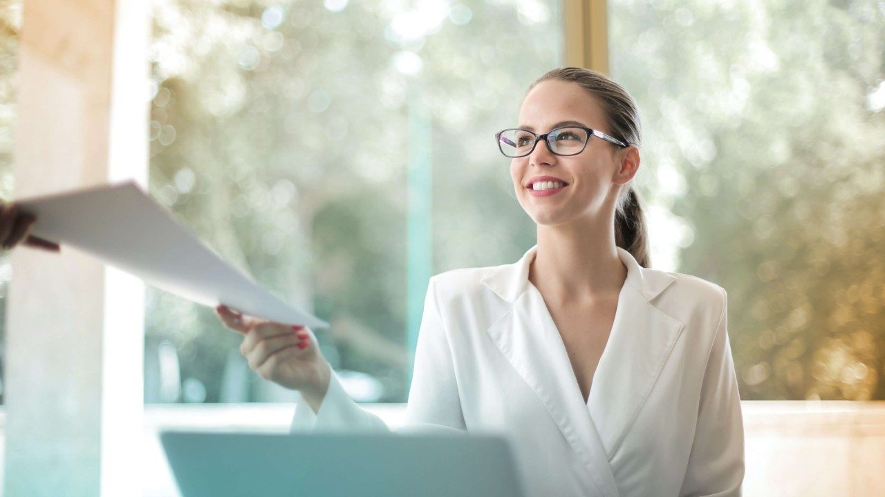 Woman at notebook watching at someone not visible in the image