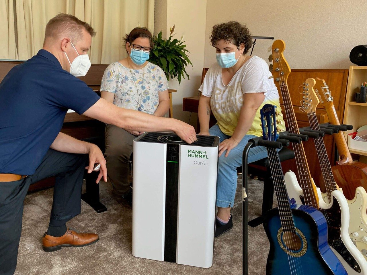 Jan-Eric Raschke, Director Air Solution Systems bei MANN+HUMMEL, erklärt Johanna Wiest (m.) und Vivien Hemmerle (r.) von der Musikschule Quintenzirkel & Meffert die Einsatzmöglichkeiten eines antiviralen Luftreinigers der Baureihe OurAir SQ 500. Übergabe fünf antiviraler Luftreiniger für Ludwigsburger Musikschule