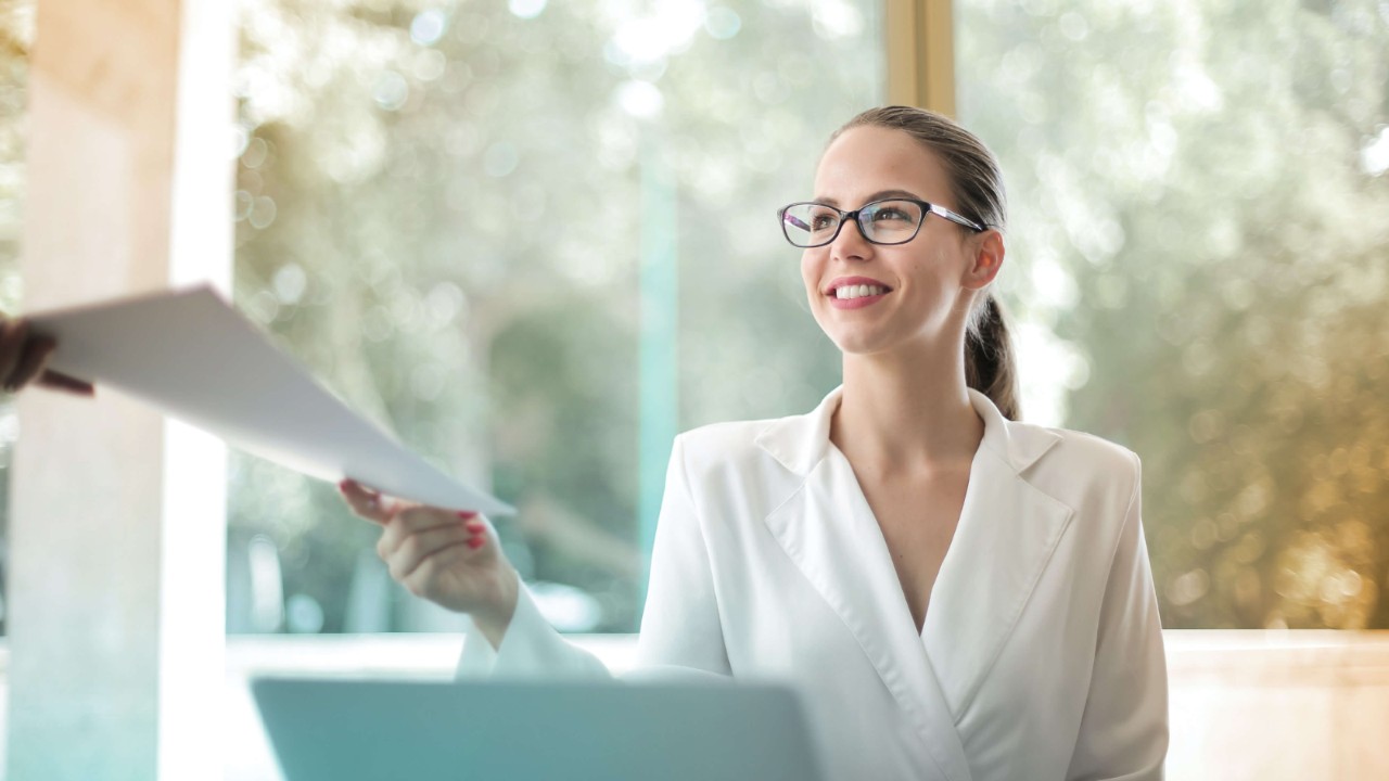 Femme à un cahier regardant quelqu’un non visible sur l’image
